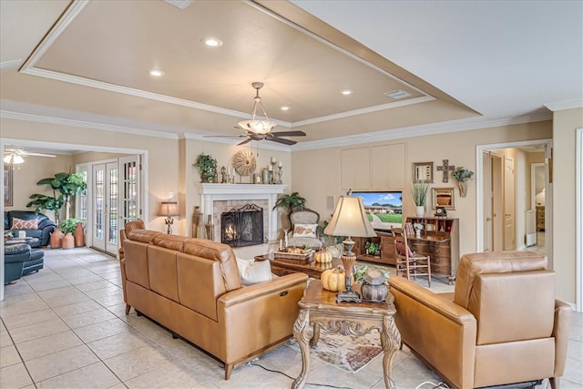 tiled living room featuring ceiling fan, crown molding, and a tray ceiling