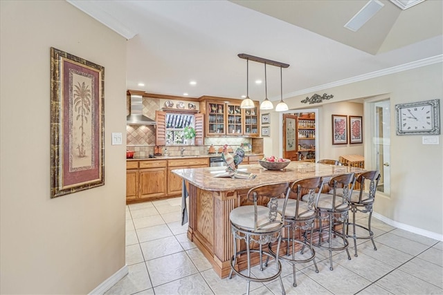 kitchen with light stone counters, a center island, a breakfast bar area, backsplash, and pendant lighting