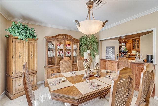 tiled dining area featuring crown molding