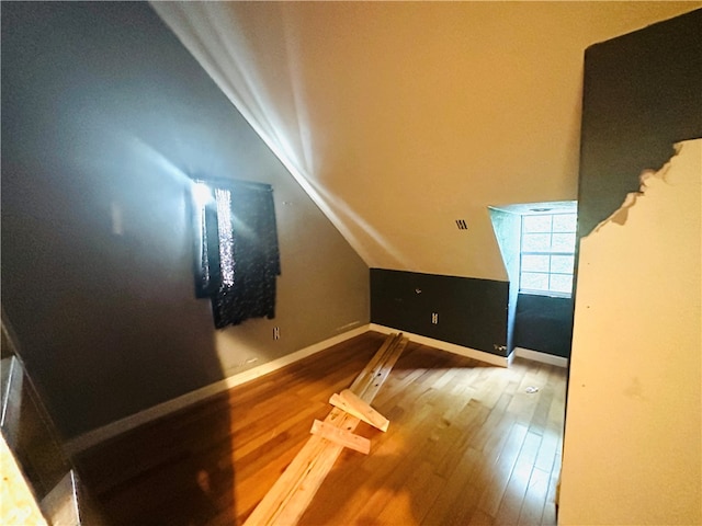 bonus room with hardwood / wood-style flooring and vaulted ceiling