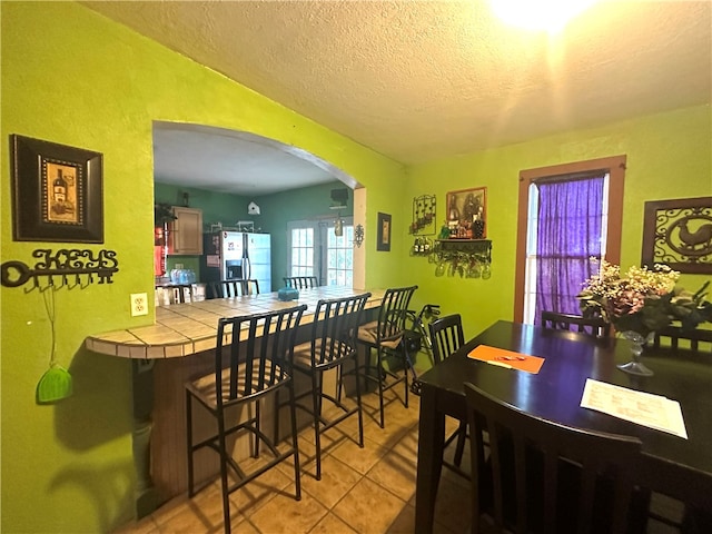 dining area featuring a textured ceiling and light tile patterned floors