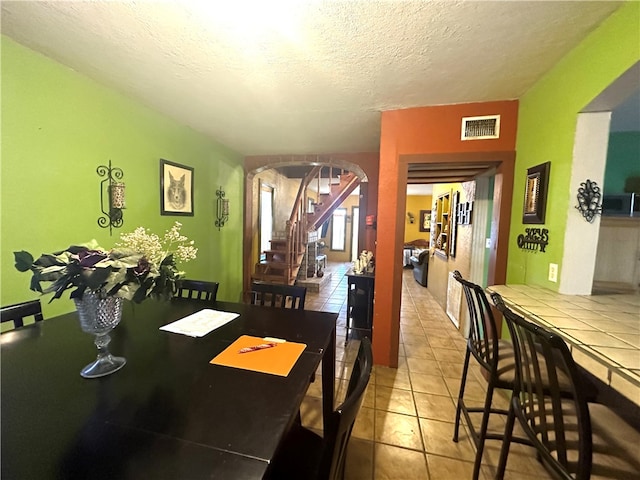 tiled dining room with a textured ceiling