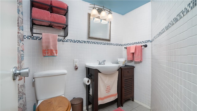 bathroom with tile walls, tile patterned flooring, vanity, and toilet