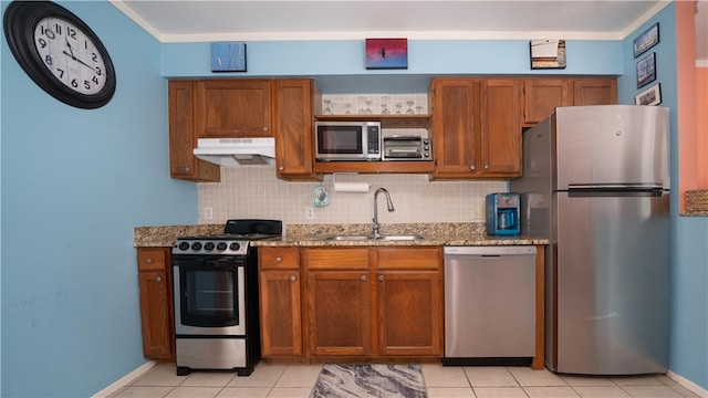 kitchen featuring stainless steel appliances, light stone counters, sink, crown molding, and backsplash