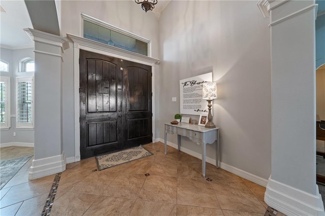 entryway featuring crown molding and decorative columns