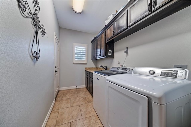 laundry area featuring cabinets, washer and clothes dryer, and sink