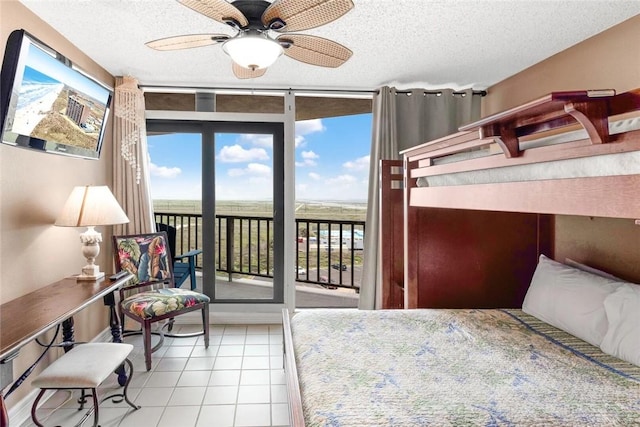 bedroom featuring tile patterned flooring, floor to ceiling windows, a textured ceiling, and access to outside