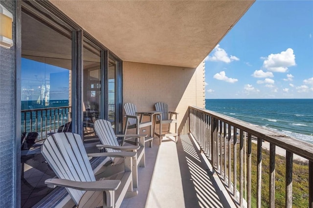 balcony featuring a water view and a beach view