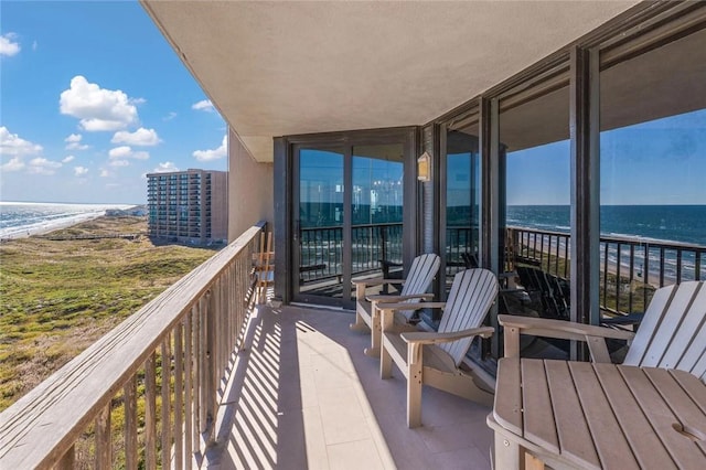 balcony featuring a beach view and a water view