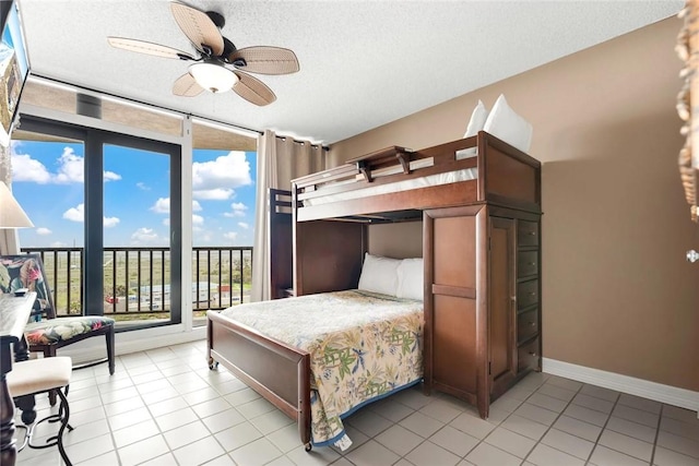 bedroom with baseboards, a textured ceiling, light tile patterned flooring, and access to outside