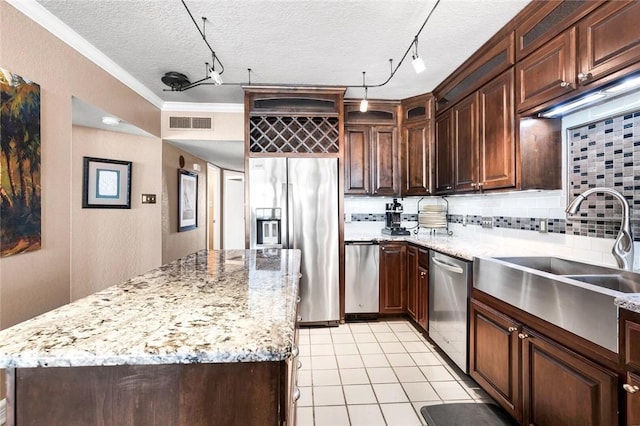 kitchen with visible vents, ornamental molding, a sink, appliances with stainless steel finishes, and decorative backsplash