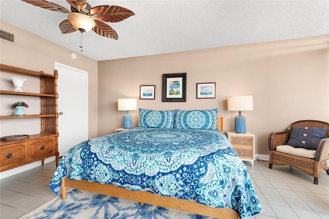 tiled bedroom with visible vents, a textured ceiling, and a ceiling fan