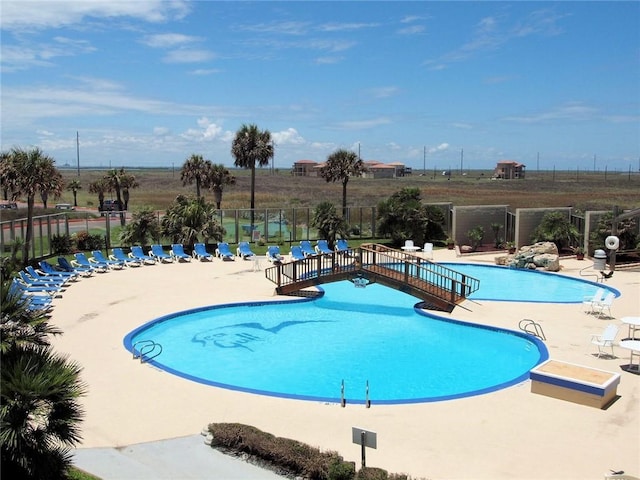 pool with a patio area and fence