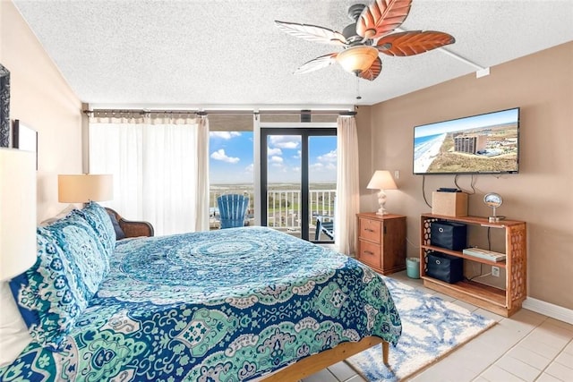 bedroom featuring tile patterned floors, ceiling fan, a textured ceiling, baseboards, and access to exterior