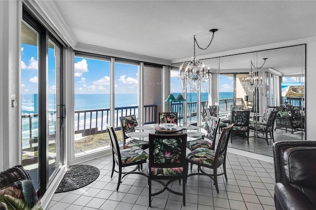 dining room featuring tile patterned flooring, a notable chandelier, a water view, and ornamental molding