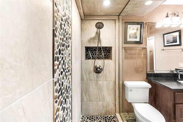 full bath featuring vanity, toilet, recessed lighting, and tiled shower