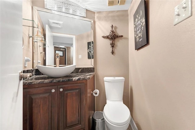 half bathroom with visible vents, toilet, and vanity