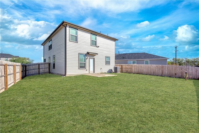 back of property with central AC unit, a patio area, and a yard