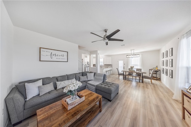 living room with light hardwood / wood-style flooring, a healthy amount of sunlight, and ceiling fan