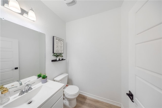 bathroom with wood-type flooring, toilet, and vanity