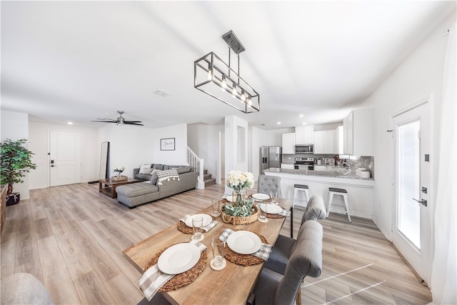 dining space with light hardwood / wood-style flooring and ceiling fan