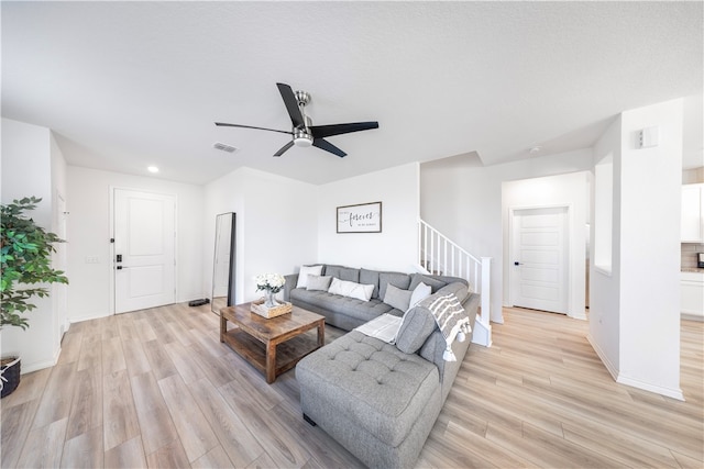 living room with ceiling fan and light hardwood / wood-style flooring