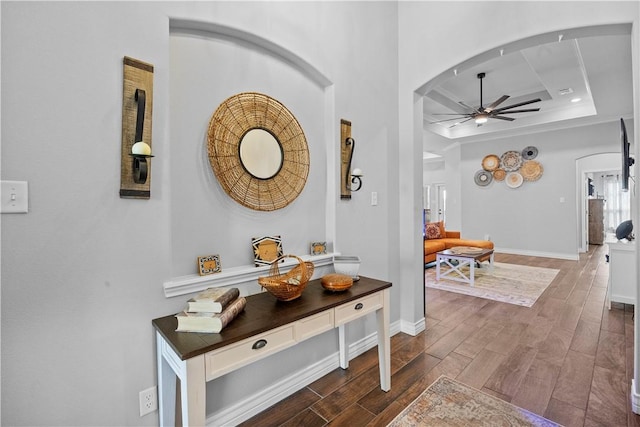 7746 Krypton Dr, Corpus Christi, TX 78414 - hallway featuring arched walkways, dark wood-type flooring, a raised ceiling, and baseboards