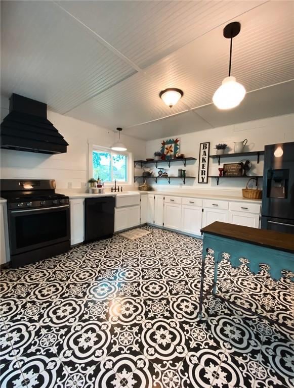 601 E Joyce St, Bishop, TX 78343 - kitchen with black appliances, premium range hood, white cabinetry, light countertops, and hanging light fixtures