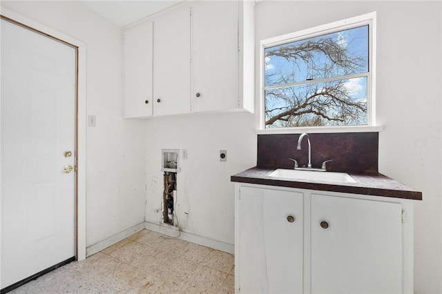 laundry area with cabinet space, hookup for an electric dryer, a sink, and baseboards