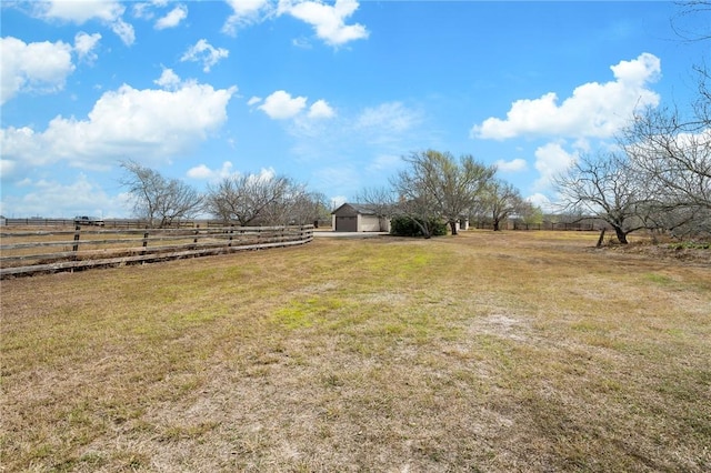 view of yard with fence and a rural view