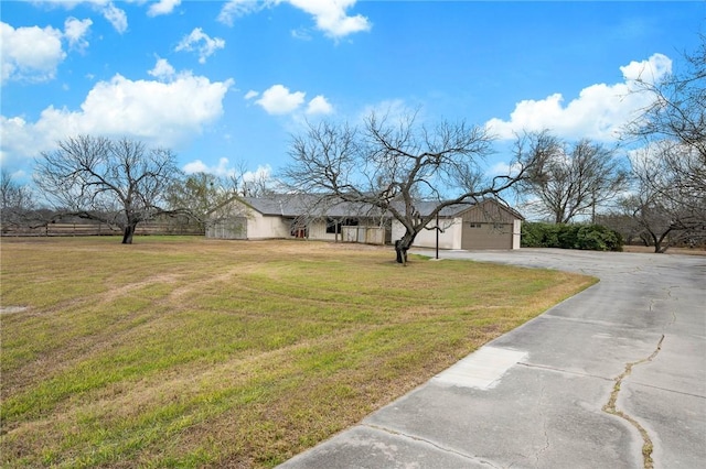 view of front facade featuring a garage, concrete driveway, and a front lawn