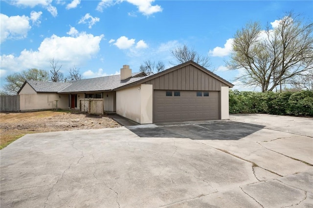 view of front of property featuring a garage, fence, and a chimney