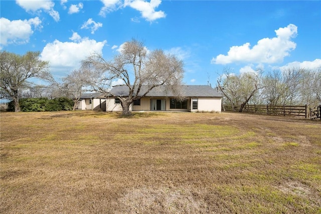 back of house featuring a lawn and fence