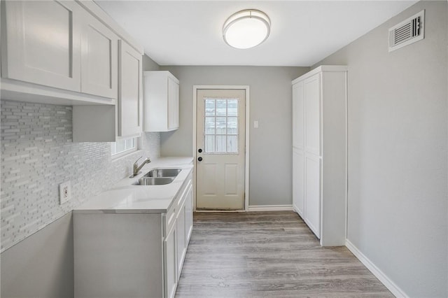 kitchen featuring white cabinetry, sink, and light hardwood / wood-style flooring