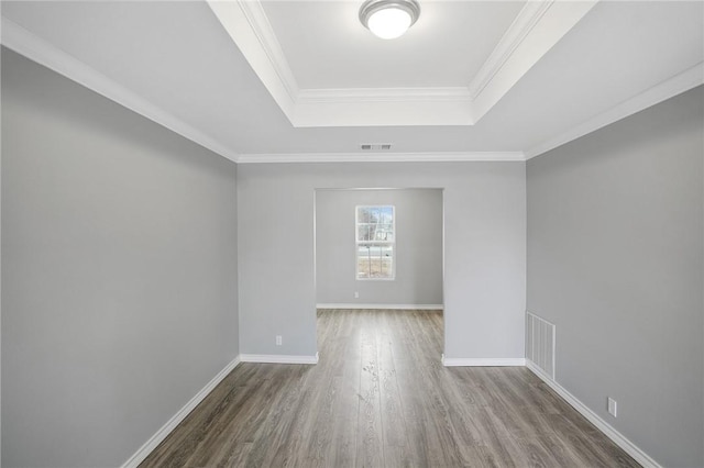 unfurnished room with crown molding, a raised ceiling, and hardwood / wood-style floors