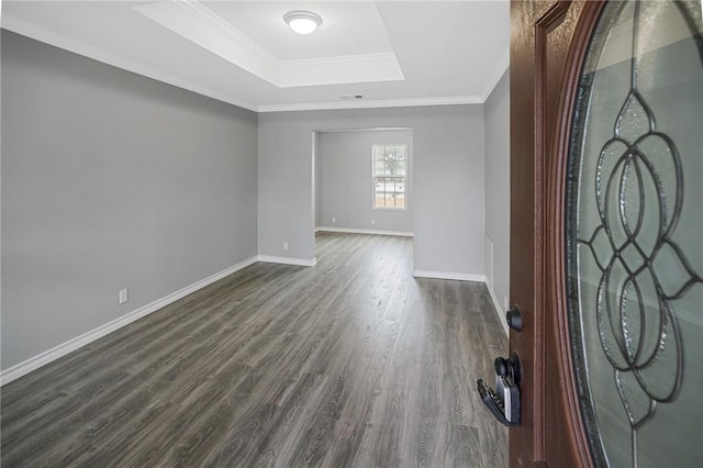 entrance foyer with a raised ceiling, ornamental molding, and dark hardwood / wood-style floors