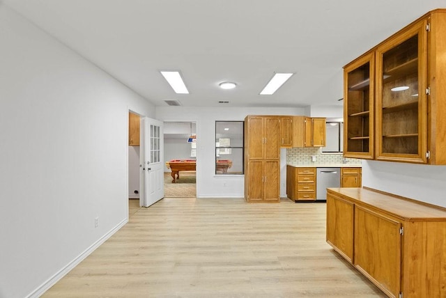2201 Woodcrest Dr, Corpus Christi, TX 78418 - kitchen with stainless steel dishwasher, light wood-style flooring, brown cabinetry, and decorative backsplash