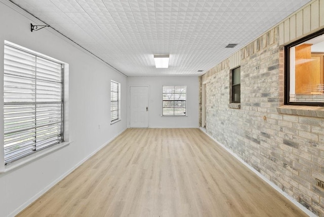 2201 Woodcrest Dr, Corpus Christi, TX 78418 - empty room featuring brick wall and light wood-type flooring