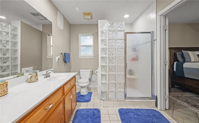 bathroom with tile patterned floors, vanity, toilet, and a shower with door