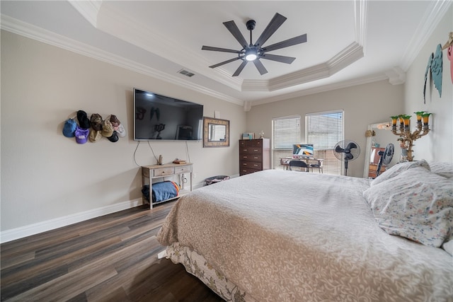 bedroom with dark wood-type flooring, a raised ceiling, ceiling fan, and crown molding