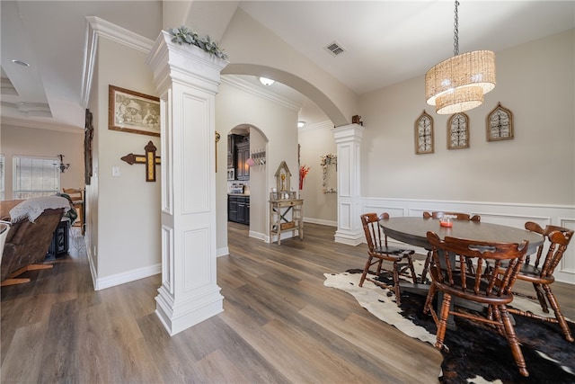 dining room with ornate columns, dark hardwood / wood-style floors, and crown molding