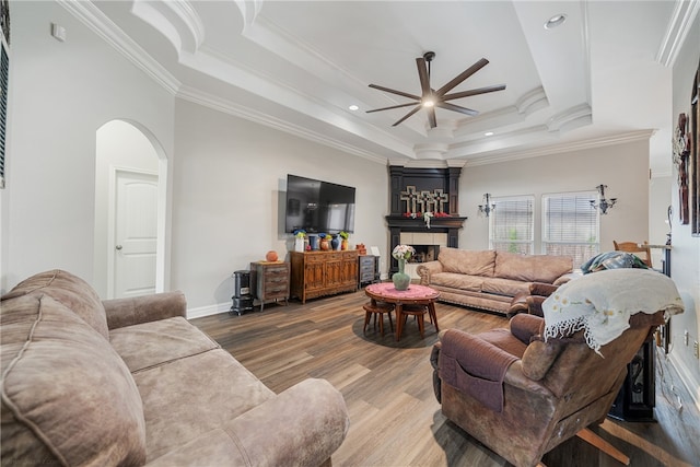 living room featuring a tray ceiling, hardwood / wood-style floors, ceiling fan, and crown molding