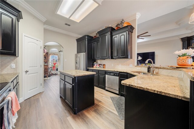 kitchen featuring ceiling fan, light hardwood / wood-style floors, crown molding, and stainless steel appliances