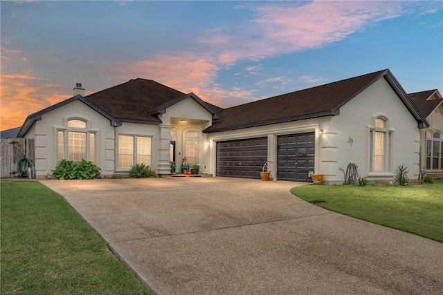 ranch-style home with a garage and a yard