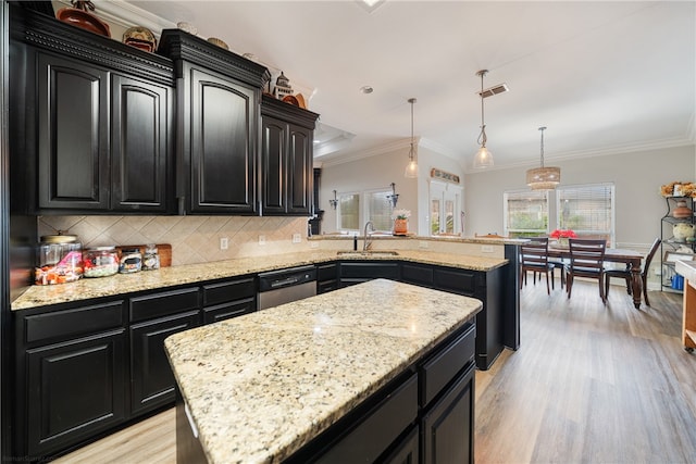 kitchen with ornamental molding, hanging light fixtures, stainless steel dishwasher, light hardwood / wood-style flooring, and a kitchen island