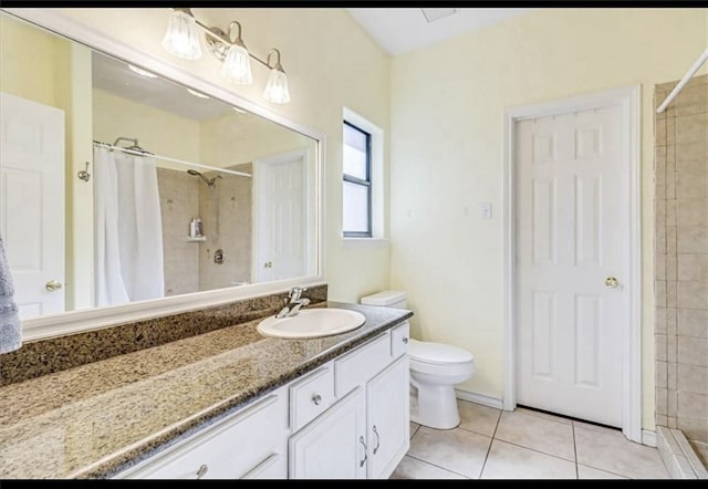 bathroom featuring toilet, vanity, tile patterned floors, and curtained shower