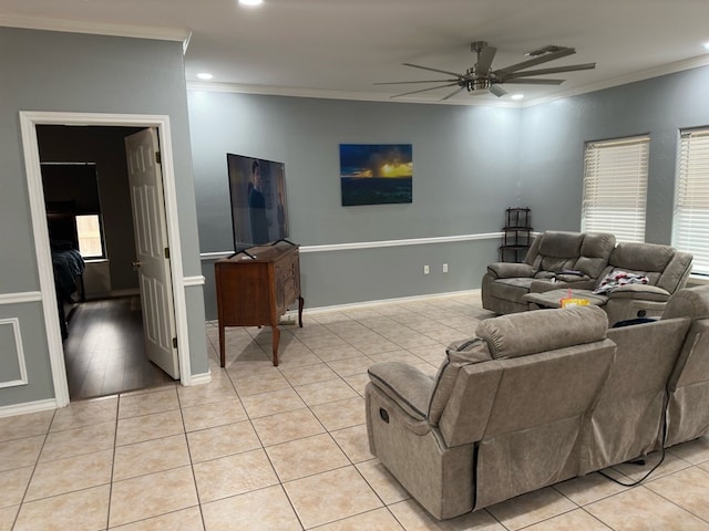 living room featuring ceiling fan, light tile patterned floors, ornamental molding, and a wealth of natural light