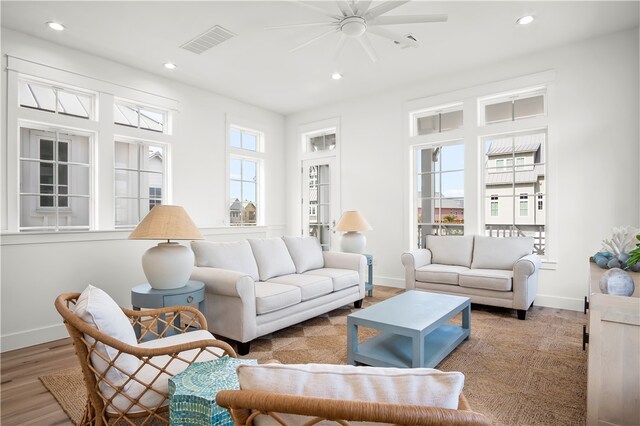 living room featuring light hardwood / wood-style flooring, plenty of natural light, and ceiling fan