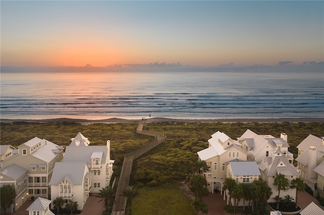 aerial view at dusk featuring a water view