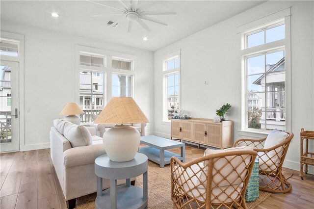 living area with light hardwood / wood-style flooring and ceiling fan